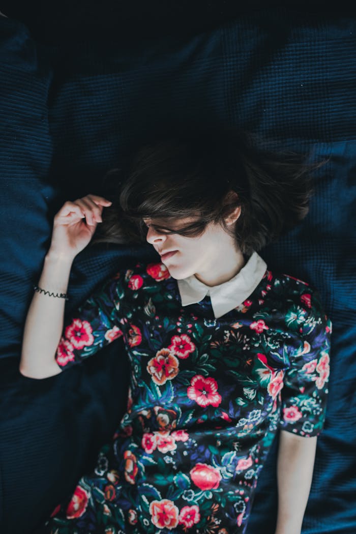 peaceful-young-woman-in-floral-dress-resting-indoors-31856021